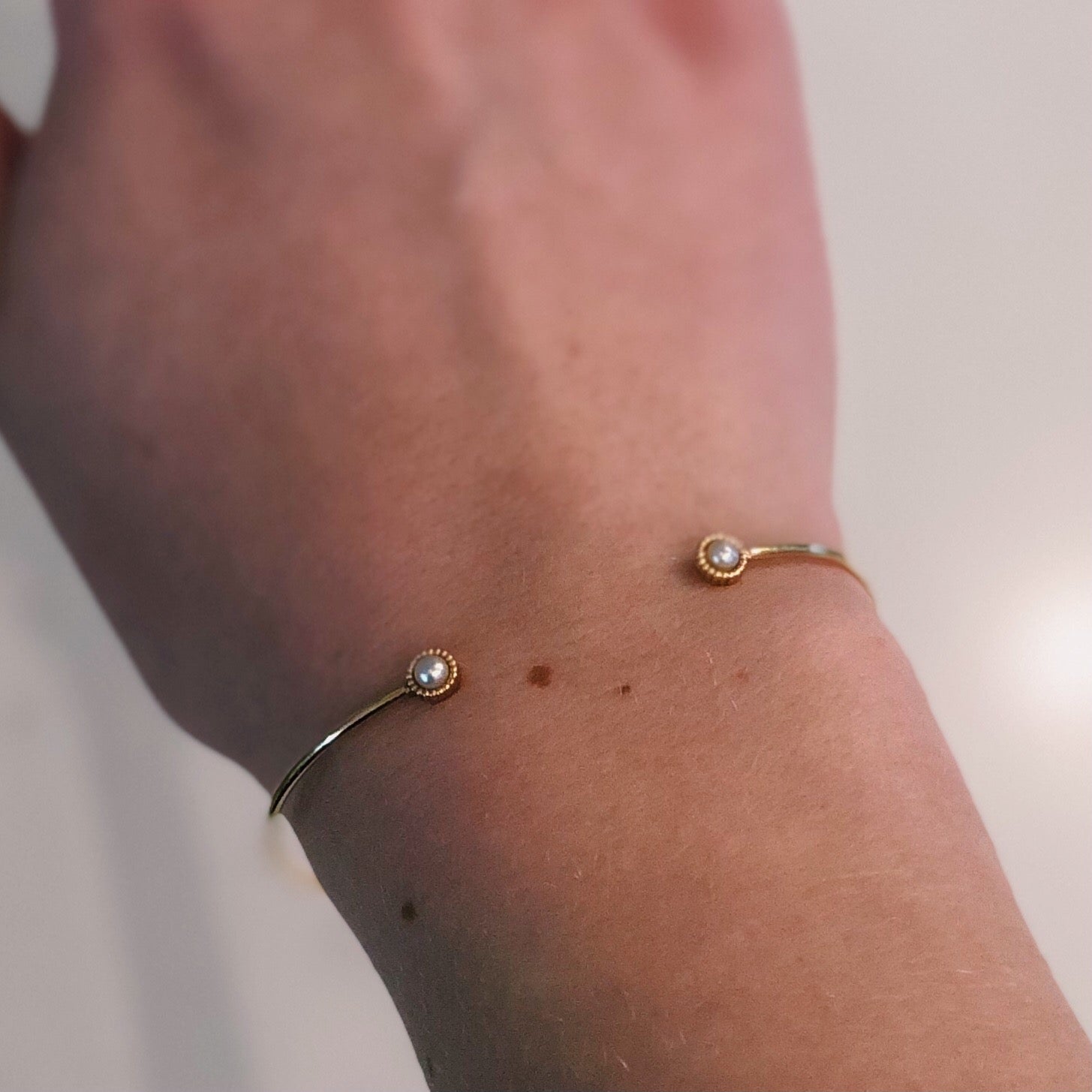 WD139-PE, 14kt gold thin cuff bracelet with 3mm bezel pearl detail on each end